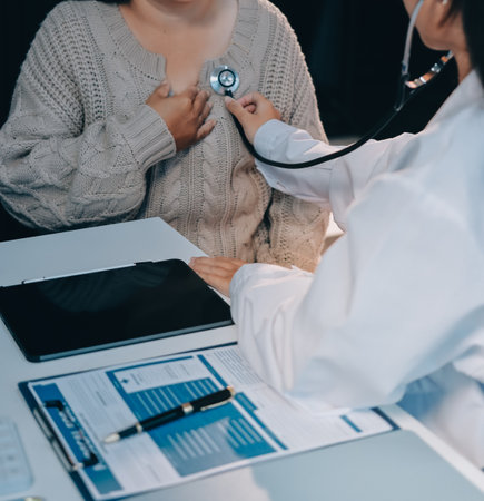 Doctor use stethoscope examining respiratory system and consultations for the elderly patients, talking check-up health or sharing test resultsの写真素材