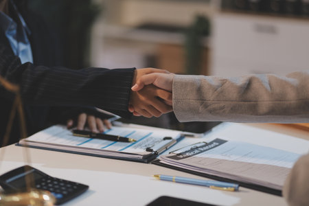 Lawyer shaking hands with a client making about documents, contracts, agreements, cooperation agreements with a female client at the lawyer's desk.の写真素材