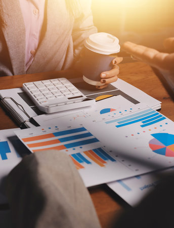 Group of confident business people point to graphs and charts to analyze market data, balance sheet,...