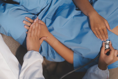 Close-up of doctor listening to a senior woman's heartbeatの写真素材
