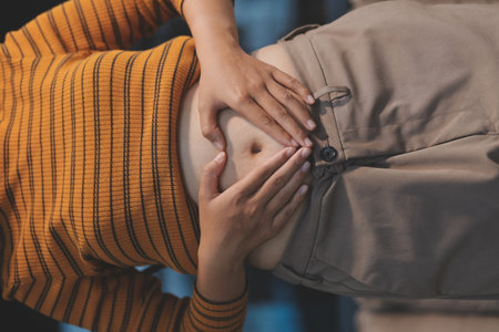 Cropped shot of woman touching and squeezing her belly.の写真素材