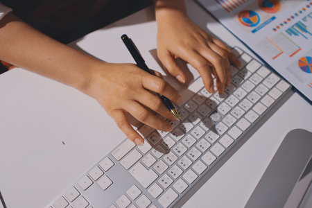 Expert woman asian female people review data number costing managerial account prepare monthly actual cost variance report at tax audit office. ESG sheet budget control ERP process service project.の写真素材