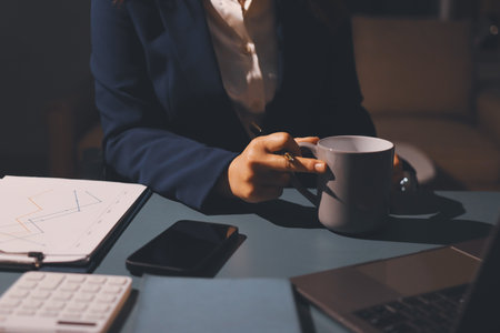 Expert woman asian female people review data number costing managerial account prepare monthly actual cost variance report at tax audit office. ESG sheet budget control ERP process service project.の写真素材