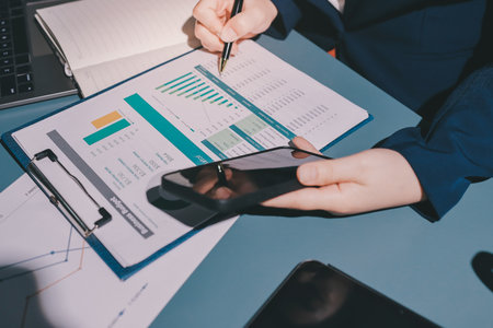 Expert woman asian female people review data number costing managerial account prepare monthly actual cost variance report at tax audit office. ESG sheet budget control ERP process service project.の写真素材