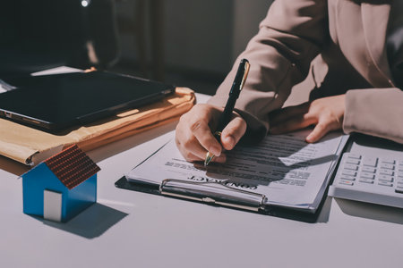 Female Real Estate Broker presenting and advised to 
model home and building project detail in the office, sign purchase sales contract, agreements concerned mortgage loan offer and insurance.の写真素材
