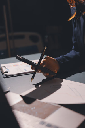 Expert woman asian female people review data number costing managerial account prepare monthly actual cost variance report at tax audit office. ESG sheet budget control ERP process service project.の写真素材