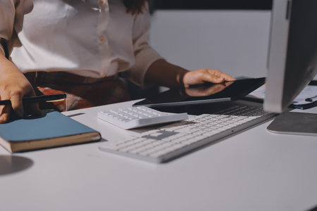 Expert woman asian female people review data number costing managerial account prepare monthly actual cost variance report at tax audit office. ESG sheet budget control ERP process service project.の写真素材