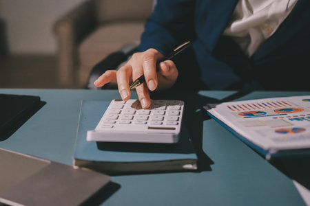 Expert woman asian female people review data number costing managerial account prepare monthly actual cost variance report at tax audit office. ESG sheet budget control ERP process service project.の写真素材