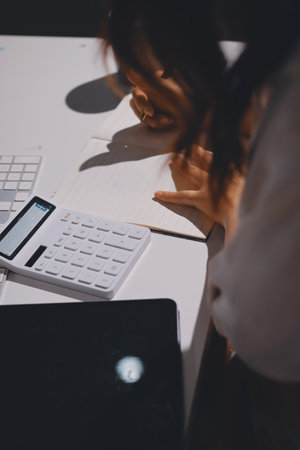 Expert woman asian female people review data number costing managerial account prepare monthly actual cost variance report at tax audit office. ESG sheet budget control ERP process service project.の写真素材