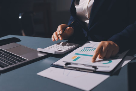 Expert woman asian female people review data number costing managerial account prepare monthly actual cost variance report at tax audit office. ESG sheet budget control ERP process service project.の写真素材