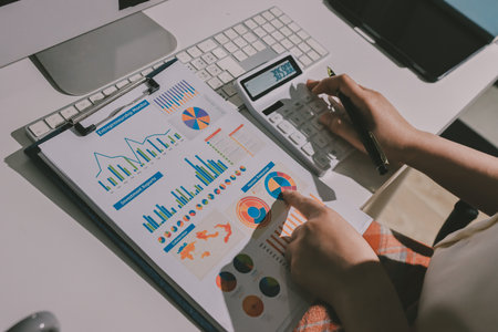 Expert woman asian female people review data number costing managerial account prepare monthly actual cost variance report at tax audit office. ESG sheet budget control ERP process service project.の写真素材