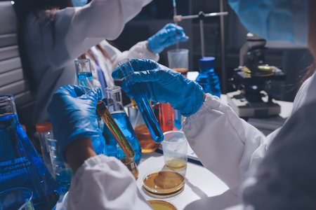 Scientist pipetting medical samples into microplate in laboratory