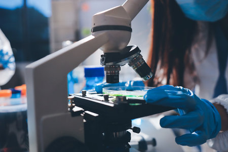 Scientist pipetting medical samples into microplate in laboratory