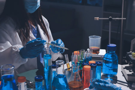 Scientist pipetting medical samples into microplate in laboratory