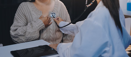 Doctor use stethoscope examining respiratory system and consultations for the elderly patients, talking check-up health or sharing test resultsの写真素材