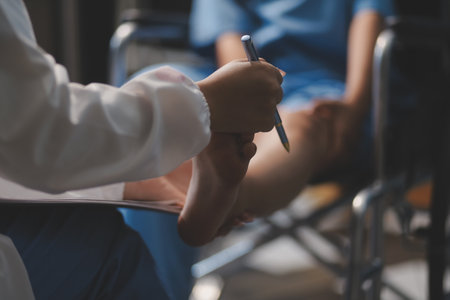 A female doctor examines an elderly patient with knee pain due to arthritis. The patient is being assisted in recovery, focusing on pain management and improving mobility.の写真素材
