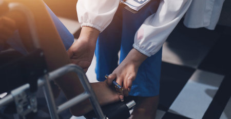 A female doctor examines an elderly patient with knee pain due to arthritis. The patient is being assisted in recovery, focusing on pain management and improving mobility.の写真素材