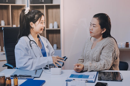 Doctor using sphygmomanometer with stethoscope checking blood pressure to a patient in the hospital.