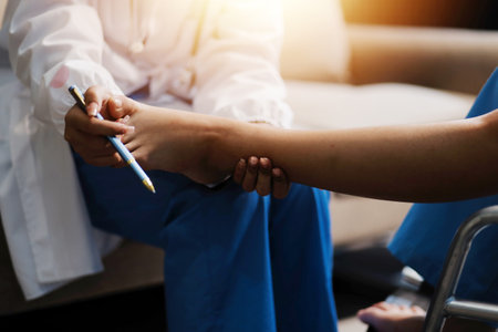 A female doctor examines an elderly patient with knee pain due to arthritis. The patient is being assisted in recovery, focusing on pain management and improving mobility.の写真素材