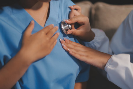 Close-up of doctor listening to a senior woman's heartbeatの写真素材