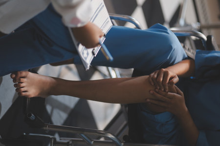A female doctor examines an elderly patient with knee pain due to arthritis. The patient is being assisted in recovery, focusing on pain management and improving mobility.の写真素材