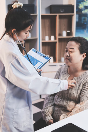 Doctor use stethoscope examining respiratory system and consultations for the elderly patients, talking check-up health or sharing test resultsの写真素材