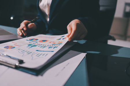 Expert woman asian female people review data number costing managerial account prepare monthly actual cost variance report at tax audit office. ESG sheet budget control ERP process service project.の写真素材