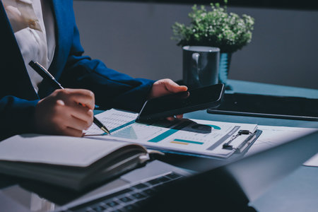 Expert woman asian female people review data number costing managerial account prepare monthly actual cost variance report at tax audit office. ESG sheet budget control ERP process service project.の写真素材