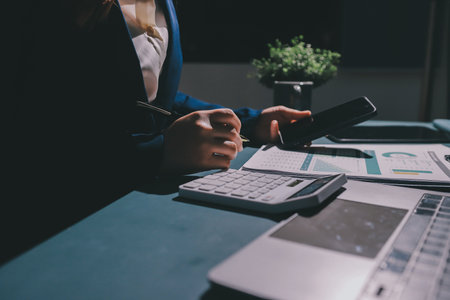 Expert woman asian female people review data number costing managerial account prepare monthly actual cost variance report at tax audit office. ESG sheet budget control ERP process service project.の写真素材
