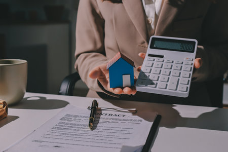 Female Real Estate Broker presenting and advised to 
model home and building project detail in the office, sign purchase sales contract, agreements concerned mortgage loan offer and insurance.の写真素材