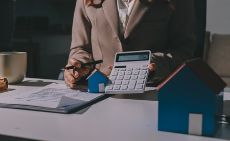 Female Real Estate Broker presenting and advised to 
model home and building project detail in the office, sign purchase sales contract, agreements concerned mortgage loan offer and insurance.の写真素材