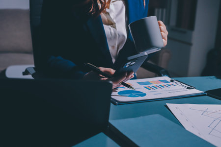 Expert woman asian female people review data number costing managerial account prepare monthly actual cost variance report at tax audit office. ESG sheet budget control ERP process service project.の写真素材