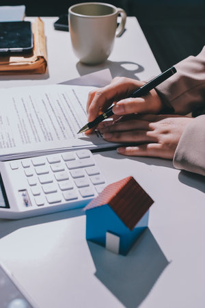 Female Real Estate Broker presenting and advised to 
model home and building project detail in the office, sign purchase sales contract, agreements concerned mortgage loan offer and insurance.の写真素材