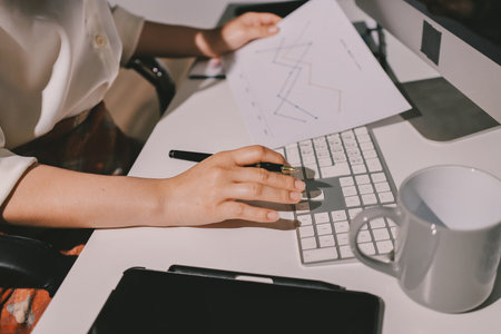 Expert woman asian female people review data number costing managerial account prepare monthly actual cost variance report at tax audit office. ESG sheet budget control ERP process service project.の写真素材