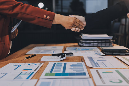 Young businessman shaking hands with businesswoman at officeの写真素材