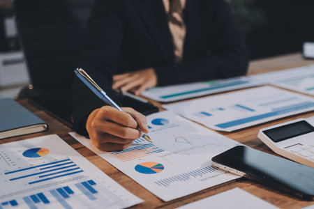 Group of business people brainstorming in analytical plan meeting Calculate the numbers obtained from the graph. Financial growth chart. Marketing. Concept of business success statistics.の写真素材
