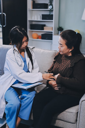 Homecare nursing service and elderly people cardiology healthcare. Close up of young female doctor nurse check mature woman patient heartbeat using stethoscope during visitの写真素材