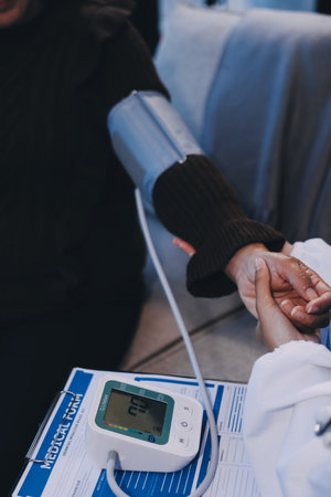 Doctor using Blood pressure monitor and stethoscope checking measuring arterial blood pressure on...