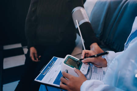 Doctor using Blood pressure monitor and stethoscope checking measuring arterial blood pressure on arm to a patient in the hospital, healthcare and medical conceptの写真素材