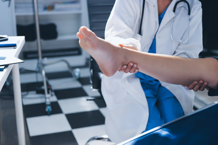 Female doctor hands doing physical therapy By extending the leg and knee of a male patientの写真素材
