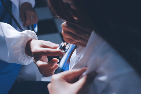 Cropped image of male doctor's hand using stethoscope to examining heartbeat and symptom of patient while talkingの写真素材