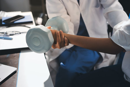 Unrecognizable uses blue hand weight during physical therapy session