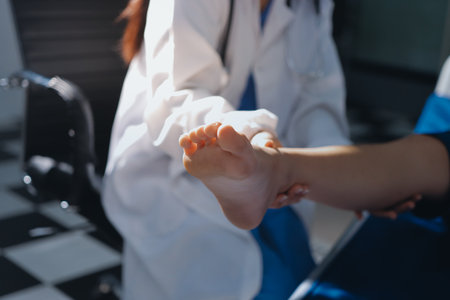 Female doctor hands doing physical therapy By extending the leg and knee of a male patientの写真素材