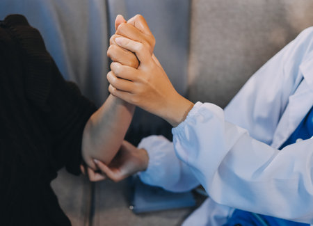 Orthopaedic doctor doing physical examination patient with wrist pain at the clinic. Physical therapist checks the patient wrist by pressing the wrist bone.の写真素材