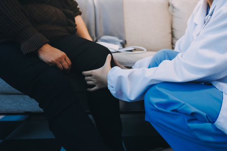 Young doctor examines senior patient's legの写真素材