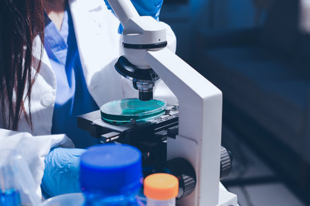 Scientist pipetting medical samples into microplate in laboratoryの写真素材
