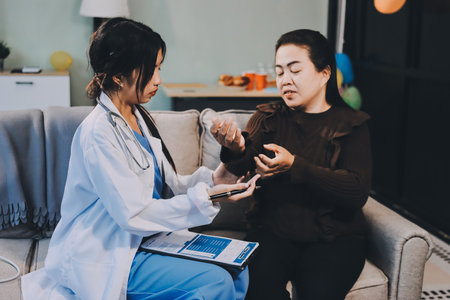 Homecare nursing service and elderly people cardiology healthcare. Close up of young female doctor nurse check mature woman patient heartbeat using stethoscope during visitの写真素材