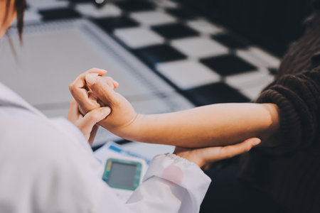 Orthopaedic doctor doing physical examination patient with wrist pain at the clinic. Physical therapist checks the patient wrist by pressing the wrist bone.の写真素材
