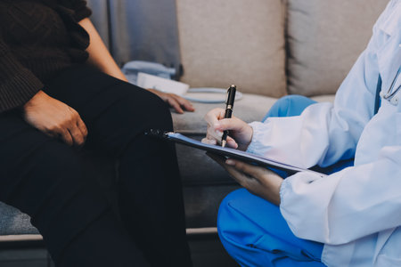 Young doctor examines senior patient's legの写真素材