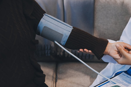 Doctor using Blood pressure monitor and stethoscope checking measuring arterial blood pressure on arm to a patient in the hospital, healthcare and medical conceptの写真素材